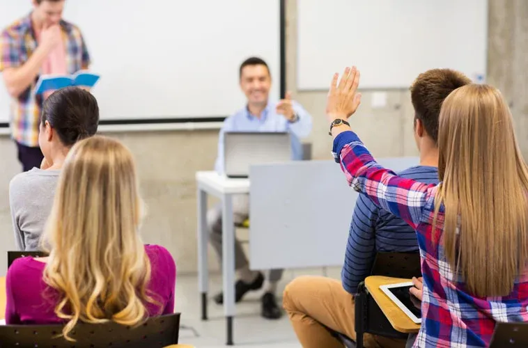 A student raising their hand to answer a question.