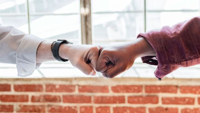 two people hand bumping